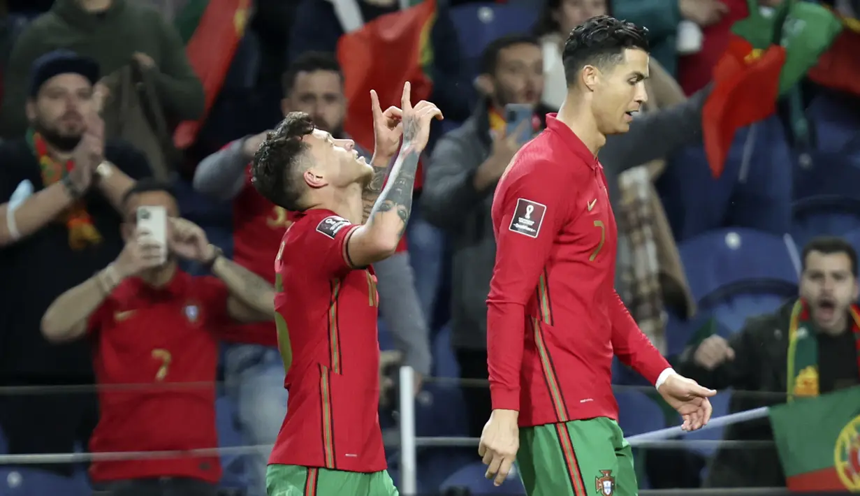 Gelandang Portugal, Otavio Monteiro (kiri) berselebrasi di samping Cristiano Ronaldo setelah mencetak gol ke gawang Turki pada pertandingan playoff Piala Dunia 2022 di stadion Dragao di Porto, Portugal, Jumat (25/3/2022). Portugal menang atas Turki 3-1. (AP Photo/Luis Vieira)