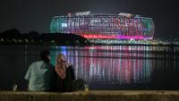 Sepasang kekasih tengah menikmati Jakarta International Stadium (JIS) yang dilihat dari Danau Cincin, Papango, Tanjung Priok, Jakarta Utara, 19 April 2022. (Bola.com/Bagaskara Lazuardi)