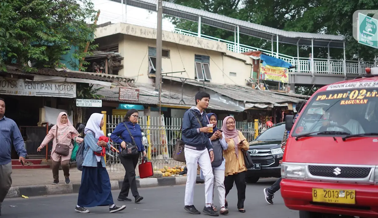Pejalan kaki menyeberangi jalan di depan Stasiun Lenteng Agung, Jakarta, Senin (4/11/2019). Meski telah tersedia JPO, sebagian pejalan kaki lebih memilih untuk menyeberang sembarangan sehingga mengganggu arus lalu lintas serta berpotensi menimbulkan kecelakaan. (Liputan6.com/Immanuel Antonius)