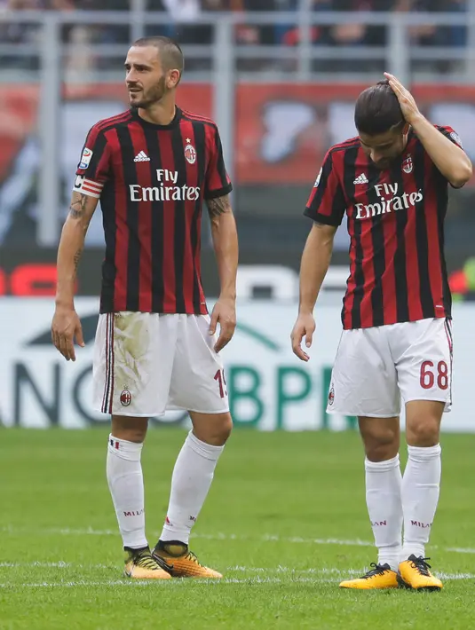 Ekspresi Leonardo Bonucci (kiri) setelah menerima kartu merah dari wasit Piero Giacomelli saat melawan Genoa pada Liga Italia di San Siro, Milan (22/10). Dalam lima laga terakhir AC Milan belum sekalipun mencicipi kemenangan. (Matteo Bazzi/ANSA via AP)