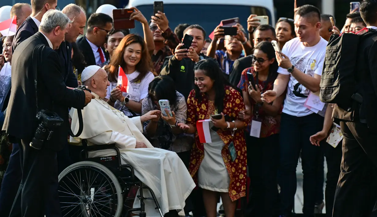 Paus Fransiskus menyapa para jemaat saat tiba di Katedral Bunda Maria Diangkat ke Surga, Jakarta pada 4 September 2024. (Tiziana FABI/AFP)