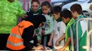 Seorang staf wanita sedang memeriksa tiket dari   suporter cilik saat memasuki stadion pada laga Saudi Pro League di King Abdullah Sports City, Jeddah, (12/1/2018). Arab Saudi untuk pertama kalinya mengizinkan wanita menonton di stadion. (AFP/STRINGER)