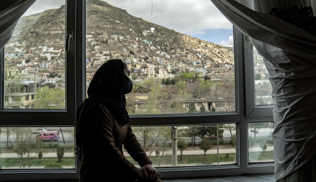 Tarawat, seorang gadis berusia 17 tahun yang telah berhenti sekolah, melihat keluar dari jendela kamarnya, di Kabul, Afghanistan, pada Sabtu, 25 Maret 2023. (AP Photo/Ebrahim Noroozi)