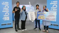 Associate VP of Digital Marketing Blibli, Maulvi Wibowo (kiri), Executive VP Marketing Blibli, I Gusti Ayu Fadjar (kedua kiri) secara simbolis menyerahkan giant key kepada pemenang Blibli Lelang Mobil Listrik Wuling Air ev, Darell Prayata (kedua kanan) didampingi orang tua (kanan) dalam program Blibili Histeria 12.12 di kantor Blibli, Jakarta (29/12/2022). (Liputan6.com)