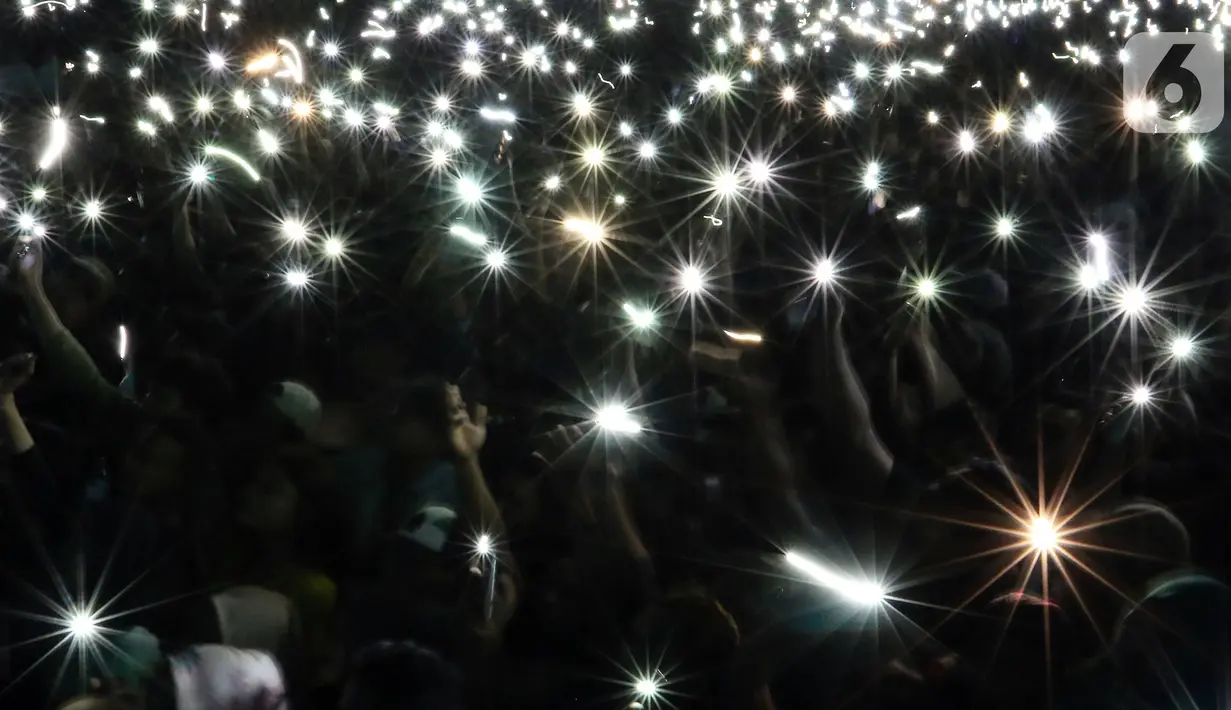 Penonton menyalakan lampu dari handphone saat menyaksikan penampilan penyanyi Didi Kempot dalam perayaan Harlah ke-20 Fraksi PKB DPR RI di Kompleks Parlemen Senayan, Jakarta, Kamis (31/10/2019). Didi Kempot membawakan sejumlah lagu di antaranya 'Kalung Emas' dan 'Cidro'. (Liputan6.com/JohanTallo)