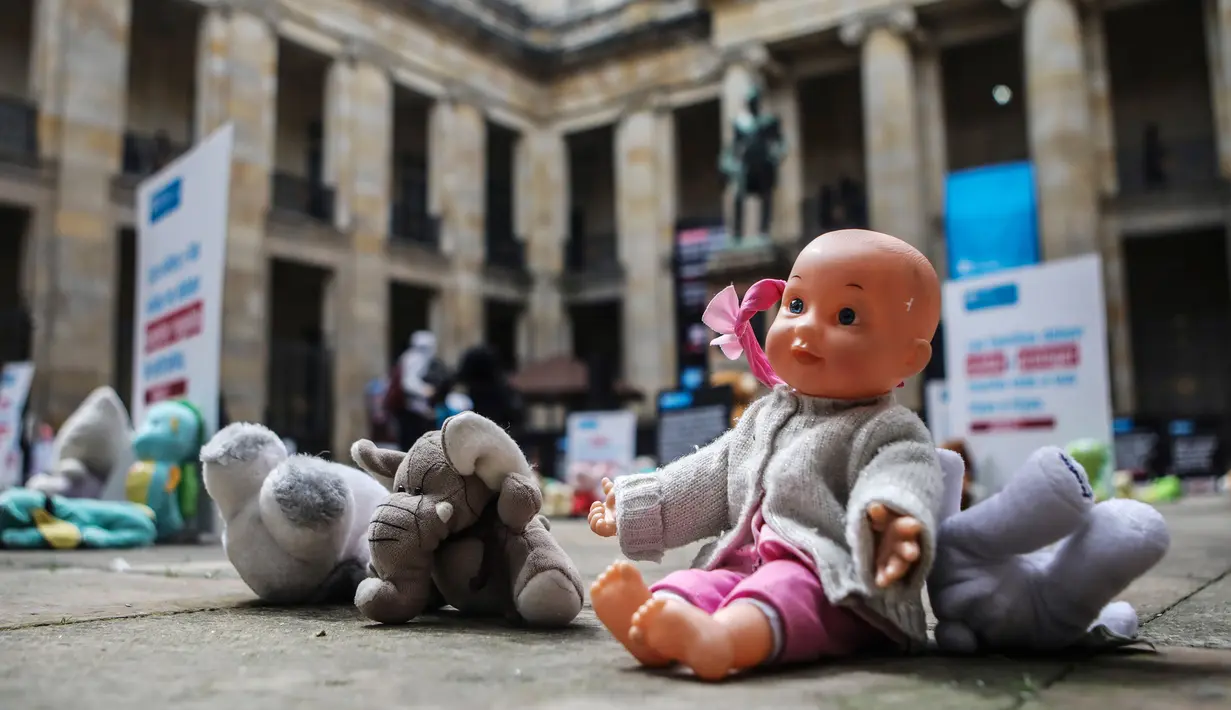 Boneka mainan diletakkan di halaman gedung Kongres Kolombia untuk memprotes kekerasan seksual terhadap anak-anak di Bogota, Selasa (20/11). Protes bertujuan untuk meningkatkan kesadaran tentang tanggung jawab perlindungan anak-anak. (DANIEL MUNOZ/AFP)