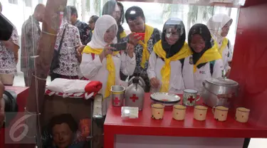 Pengunjung mengamati barang koleksi PMI yang dipamerkan dalam rangka peringatan HUT ke-70 PMI di Museum Nasional, Jakarta, Kamis (10/9). Merayakan hari jadinya, PMI menggelar pameran dan peluncuran prangko. (Liputan6.com/Angga Yuniar)