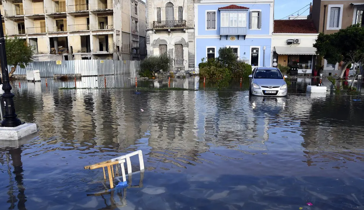 Air laut menutupi jalan setelah gempa bumi di pelabuhan Vathi di pulau Aegean timur Samos, Yunani (30/10/2020). Gempa bumi kuat melanda Laut Aegea antara pantai Turki dan pulau Samos di Yunani. (AP Photo / Michael Svarnias)