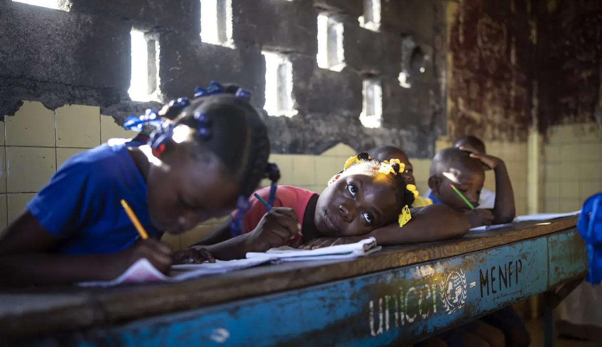 Para siswa menulis saat menghadiri kelas di sekolah Sante Bernadette, di dalam Fort Dimanche di Port-au-Prince, Haiti, Kamis (23/9/2021). Sekolah ini pernah menjadi penjara di mana mendiang diktator Francois "Papa Doc" Duvalier memenjarakan musuh-musuhnya. (AP Photo/Rodrigo Abd)