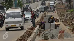 Pekerja saat menyelesaikan proyek rehabilitasi ruas jalan Ciputat-Pamulang, Tangerang Selatan, (28/1). Akibat pengerjaan lalu lintas mengalami kemacetan. (Liputan6.com/Faisal R Syam)