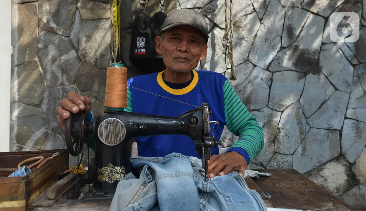 Sutayono menyelesaikan jahitan pelanggan di kawasan Matraman, Jakarta, Jumat (24/7/2020). Pria 74 tahun yang rencananya berangkat menunaikan ibadah haji pada 2022 mendatang, harus menunggu lagi hingga 2024 akibat keberangkatannya diundur karena pandemi Covid-19. (merdeka.com Imam Buhori)