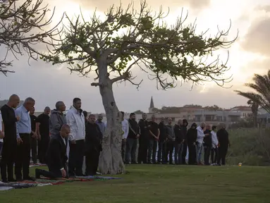 Umat muslim berkumpul untuk melaksanakan salat Idul Fitri yang menandai berakahirnya bulan suci Ramadan di sebuah taman di Jaffa, Israel, Minggu (24/5/2020). Jaffa merupakan kota campuran Yahudi-Arab. (AP Photo/Oded Balilty)