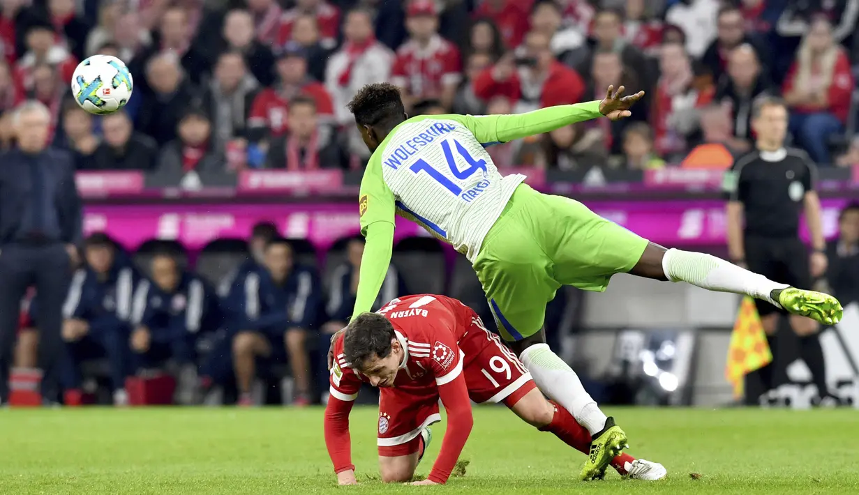 Gelandang Bayern Munchen, Sebastian Rudy, terjatuh saat berebut bola dengan striker VfL Wolfsburg, Divock Origi, pada laga Bundesliga, di Stadion Allianz, Kamis (22/9/2017). Bayern Munchen ditahan imbang 2-2 oleh VfL Wolfsburg. (AP/Matthias Balk)