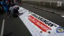 Pengunjung car free day membubuhkan tanda tangan di atas spanduk dukungan untuk atlet Indonesia di Bundaran HI, Jakarta, Minggu (18/3). Aksi  itu bentuk dukungan bagi atlet Indonesia yang akan berlaga di Asian Games 2018. (Liputan6.com/Faizal Fanani)
