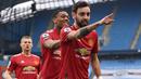 Gelandang Manchester United, Bruno Fernandes (depan) melakukan selebrasi usai mencetak gol pertama timnya ke gawang Manchester City melalui eksekusi penalti dalam laga lanjutan Liga Inggris 2020/21 di Etihad Stadium, Minggu (7/3/2021). MU menang 2-0 atas Mancity. (AFP/Laurence Griffiths/Pool)