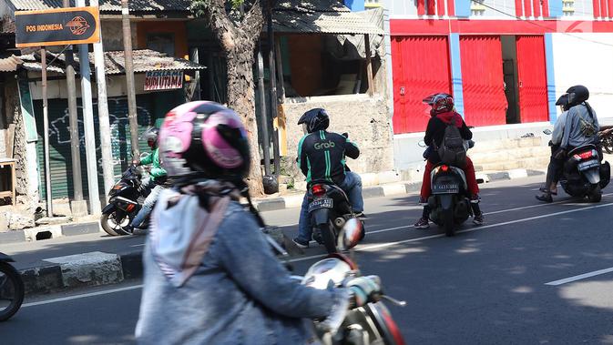 Sejumlah pengendara sepeda motor hendak putar balik dan melawan arus di kawasan Jagakarsa, Jakarta, Minggu (6/1). Jauhnya akses putar balik menyebabkan para pemotor nekat melawan arah, meskipun berbahaya bagi keselamatan. (Liputan6.com/Immanuel Antonius)