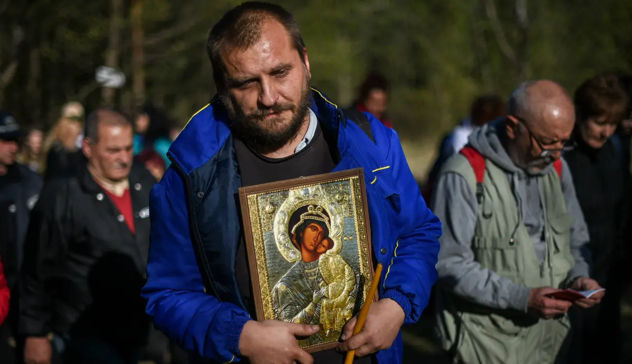 Seorang pria membawa simbol Perawan Maria selama prosesi keagamaan tahunan di Biara Bachkovo, Bulgaria (9/4). Prosesi keagamaan yang diadakan tiap tahun ini dilaksanakan pada hari kedua Paskah Ortodoks. (AFP Photo/Nikolay Doychinov)