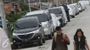 Pejalan kaki melintas di jalur inspeksi Kanal Banjir Barat, Jakarta, Senin (6/3). Keterbatasan lahan menyebabkan sejumlah kendaraan parkir di tempat tersebut, meskipun telah terpampang larangan parkir. (Liputan6.com/Immanuel Antonius)