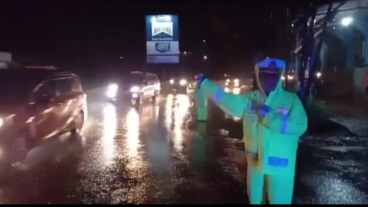 Di tengah guyuran hujan rincik yang membasahi langit Garut, sejak Sabtu petang, tak merintangi petugas jaga mengamankan jalur mudik nasional Limbangan-Malangbong, Garut, Jawa Barat. (Liputan6.com/Jayadi Supriadin)