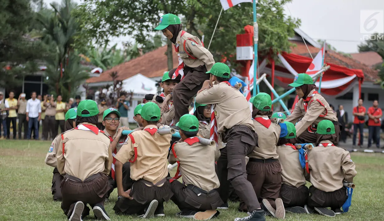 Para peserta pramuka menunjukan keahlianya dalam perayaan HUT ke-57 Pramuka di Lapangan Gajah Mada, Cibubur, Jakarta, Selasa (14/8). Perayaan ke-57 Pramuka kali ini mengangkat tema 'Pramuka Perekat NKRI'. (Liputan6.com/Faizal Fanani)