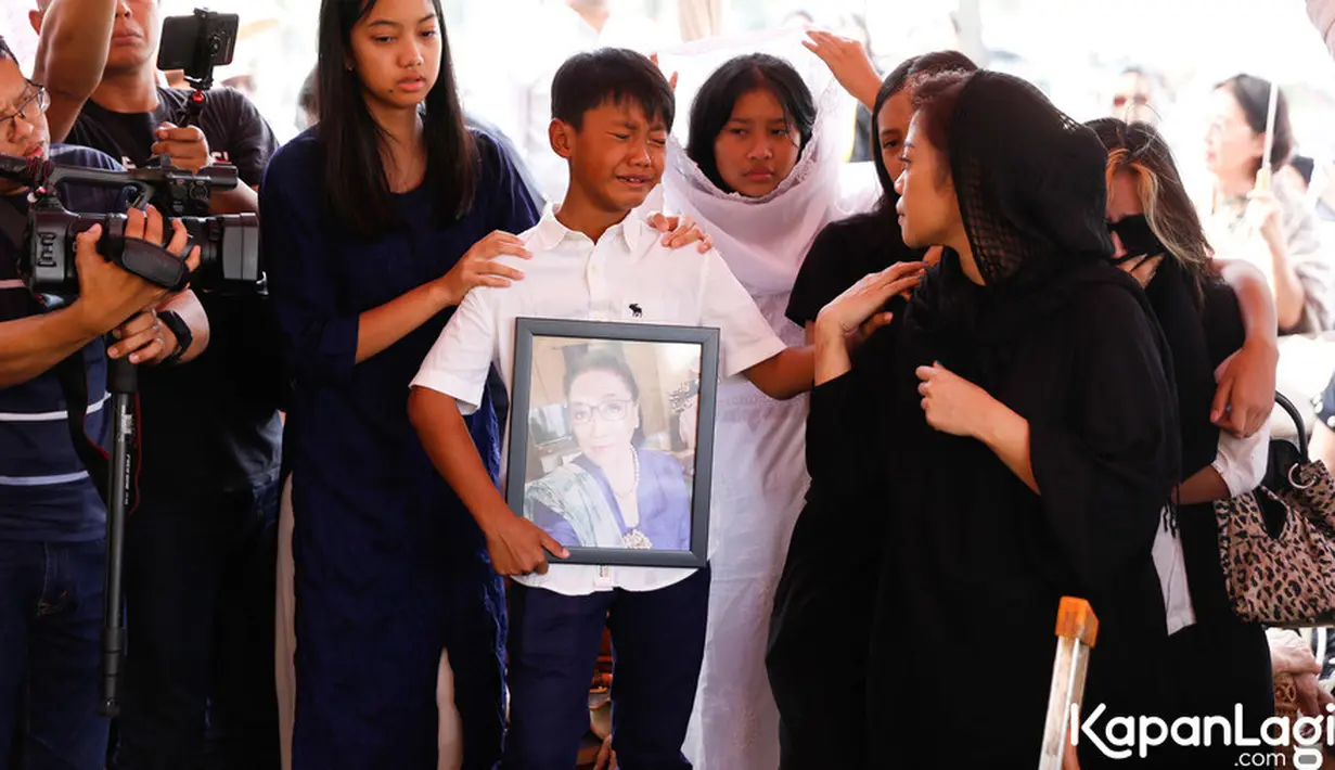 Isak tangis dari anak cucu mengiringi selama prosesi pemakaman. Kikan juga tak kuasa menahan air mata menyaksikan jenazah ibunda yang mulai tertutup dengan tanah merah. [Foto: KapanLagi.com/Bayu Herdianto]
