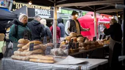 Pelanggan berbelanja roti di kios pasar di Walthamstow, London timur pada 13 Februari 2022. Inflasi tahunan Inggris mencapai 5,4 persen pada Desember, memicu kekhawatiran tekanan biaya hidup karena upah gagal mengimbangi. (Tolga Akmen / AFP)