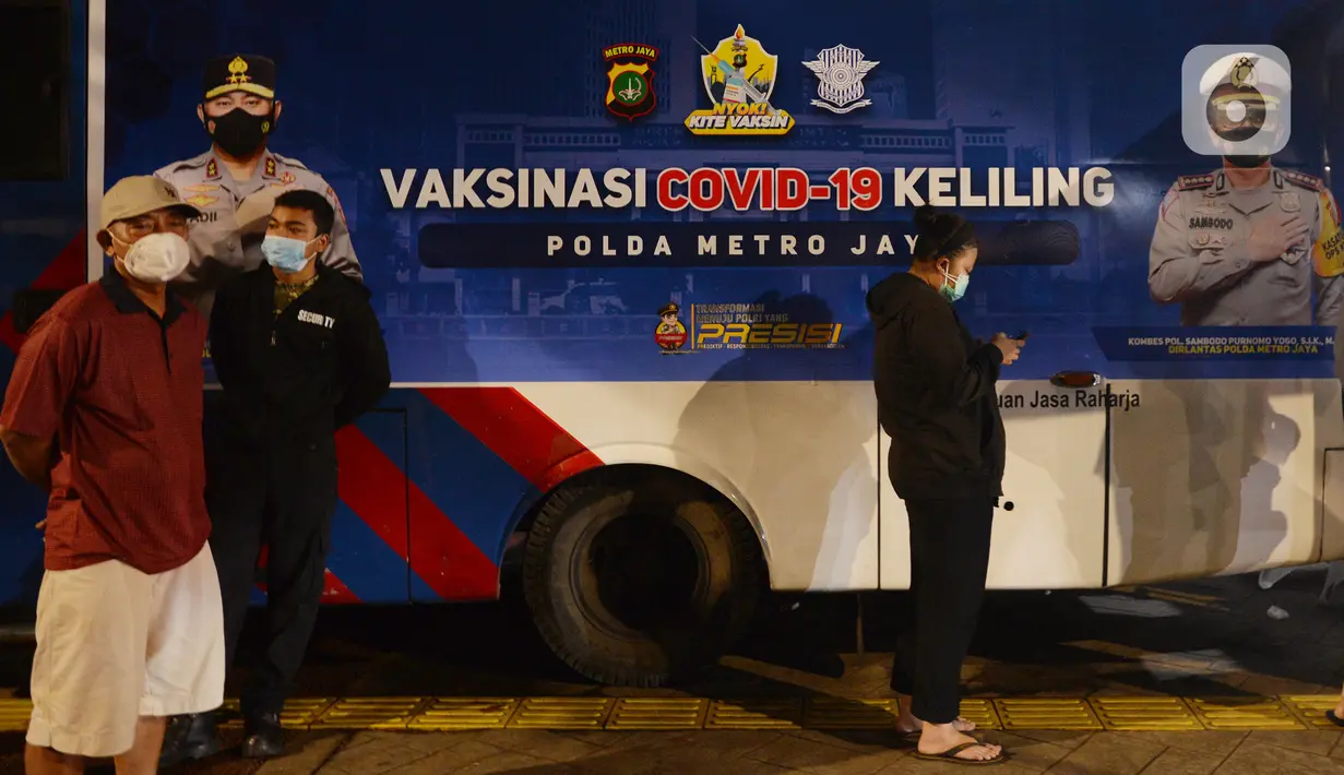 Warga menunggu untuk mengikuti Vaksinasi Covid-19 di Kawasan Bulungan, Jakarta, Kamis (24/6/2021). Polda Metro Jaya membuka layanan vaksinasi Covid secara massal dengan berkeliling di Kawasan Bulungan, Jakarta, Kamis (24/6/2021). Malam. (merdeka.com/Imam Buhori)