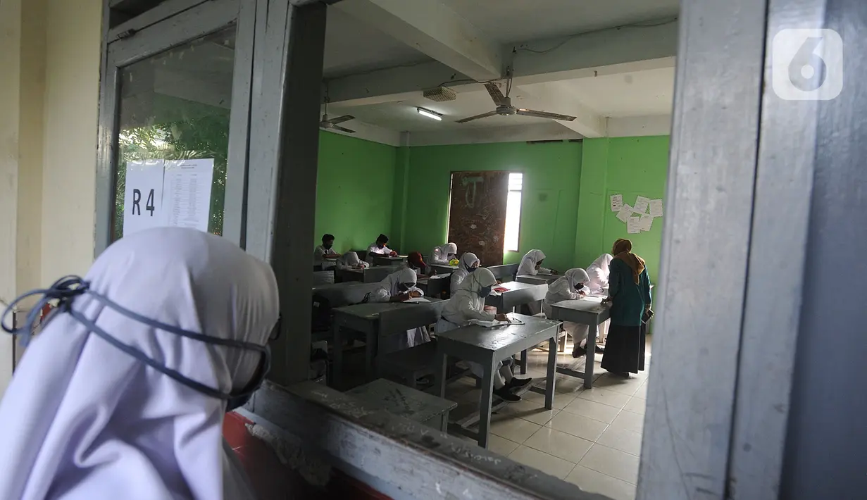 Murid baru menggunakan masker  mengikuti tes penentuan kelas tahun ajaran 2020-2021 yang selanjutnya akan mengikuti kegiatan belajar mengajar (KBM) secara darling di MTs Hidayatul Umami, Cinere, Depok, Jawa Barat, Senin (13/7/2020). (merdeka.com/Arie Basuk)