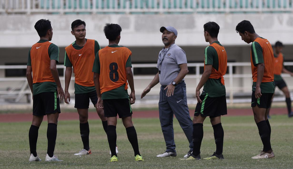 Pelatih Timnas Indonesia U-19, Fakhri Husaini, memberikan arahan kepada pemainnya saat latihan di Stadion Pakansari, Bogor, Rabu (2/10). Latihan ini merupakan persiapan jelang AFF U-19 di Vietnam. (Bola.com/Yoppy Renato)