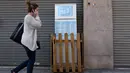 Seorang wanita berjalan melewati sebuah kulkas yang ditempatkan di pinggir trotoar Galdakao, Senin (31/5). Kulkas yang disebut 'solidarity fridge' itu digunakan untuk mengatasi pemborosan makanan di kota utara Spanyol tersebut. (Ander GILLENEA/AFP)