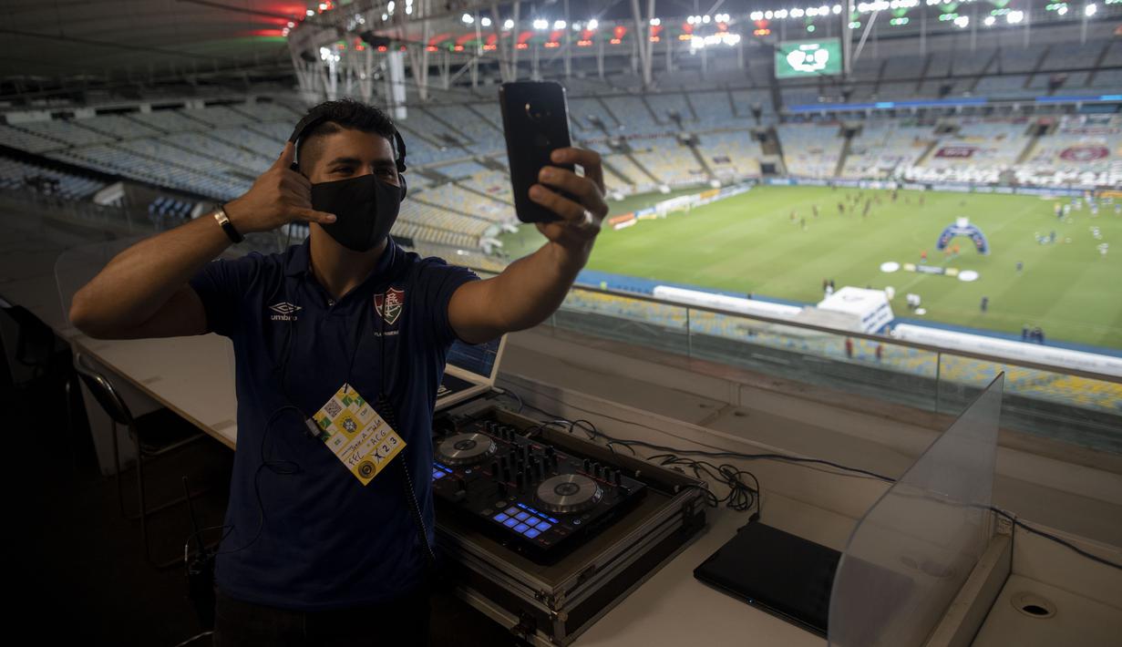 DJ Franklin Scheleger (29) berswafoto sebelum memainkan suara dan lagu menyerupai gemuruh suporter selama pertandingan antara Fluminense dan Atletico Goianiense dalam babak lanjutan Kejuaraan Brasil di Stadion Maracana, Rio de Janeiro, Brasil, pada 2 September 2020. (AFP/Mauro Pimentel)