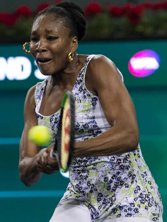 Venus Williams memukul bola saat melawan adiknya Serena Williams saat putaran ketiga turnamen tenis BNP Paribas Open Open di Indian Wells Tennis Garden, California (12/3). Venus Williams menang 6-3, 6-4.  (AP Photo/Crystal Chatham)