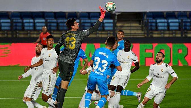 Kiper Real Madrid, Thibaut Courtois, berusaha menepis bola saat melawan Valencia pada laga lanjutan La Liga Spanyol pekan ke-29 di Stadion Alfredo, Stefano, Jumat (19/6/2020) dini hari WIB. Real Madrid menang 3-0 atas Valencia. (AFP/Javier Soriano)