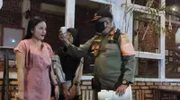 Seorang pengunjung kafe di Kota Palembang, mendapat sanksi menyanyikan lagu nasional, setelah kedapatan tim Satpol-PP Sumsel tidak membawa masker (Liputan6.com / Nefri Inge)