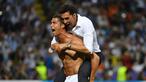Cristiano Ronaldo menggendong salah satu staf Real Madrid saat merayakan kemenangan usai mengalahkan Atletico Madrid pada Final Liga Champions di San Siro Stadium, Milan, (29/5/2016) WIB. (AFP/Gerard Julien)