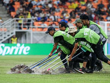 Sejumlah petugas menyingkirkan air yang menggenangi lapangan Jakarta International Stadium (JIS) jelang laga perempat final Piala Dunia U-17 2023 antara Timnas Brasil U-17 melawan Timnas Argentina U-17, Jumat (24/11/2023). (Bola.com/Bagaskara Lazuardi)