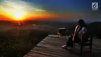 Seorang wisatawan menunggu matahari terbenam di Puncak Watu Goyang usai berkeliling dengan jip di Desa Wisata Kaki Langit Mangunan, Bantul, Yogyakarta (4/5). (Merdeka.com/Arie Basuki)