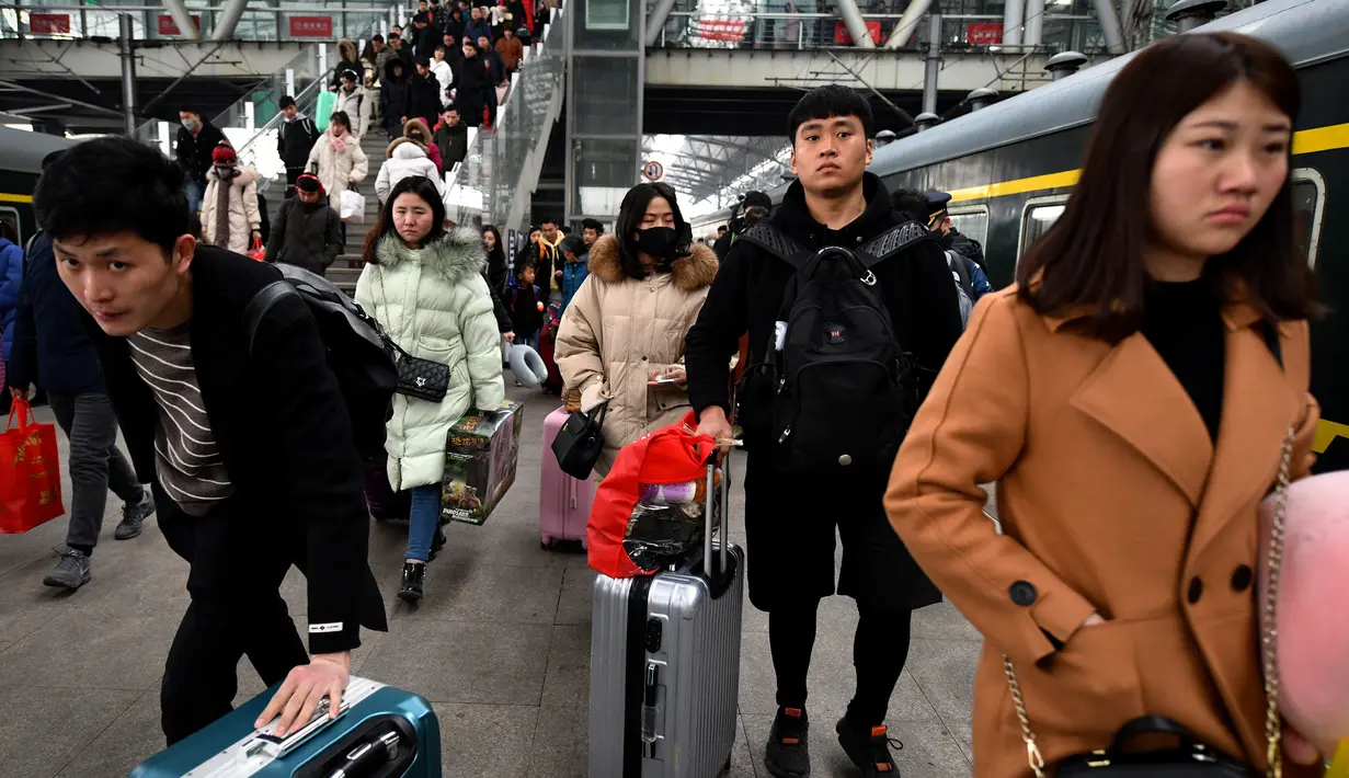 Calon penumpang membawa barang bawaan saat akan naik kereta di sebuah stasiun di Fuyang, Provinsi Anhui, China, Minggu (10/2). Pulang ke kampung halaman menjadi tradisi warga China saat Tahun Baru Imlek. (Chinatopix via AP)