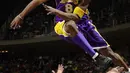 Pemain Los Angeles Lakers, Kobe Bryant melompati deretan penggemar setelah menyelamatkan bola saat bertanding melawan Houston Rockets di Houston pada 20 Desember 2001. Bryant memenangkan lima gelar juara NBA dan peraih medali emas Olimpiade dua kali. (AP Photo/Pat Sullivan)