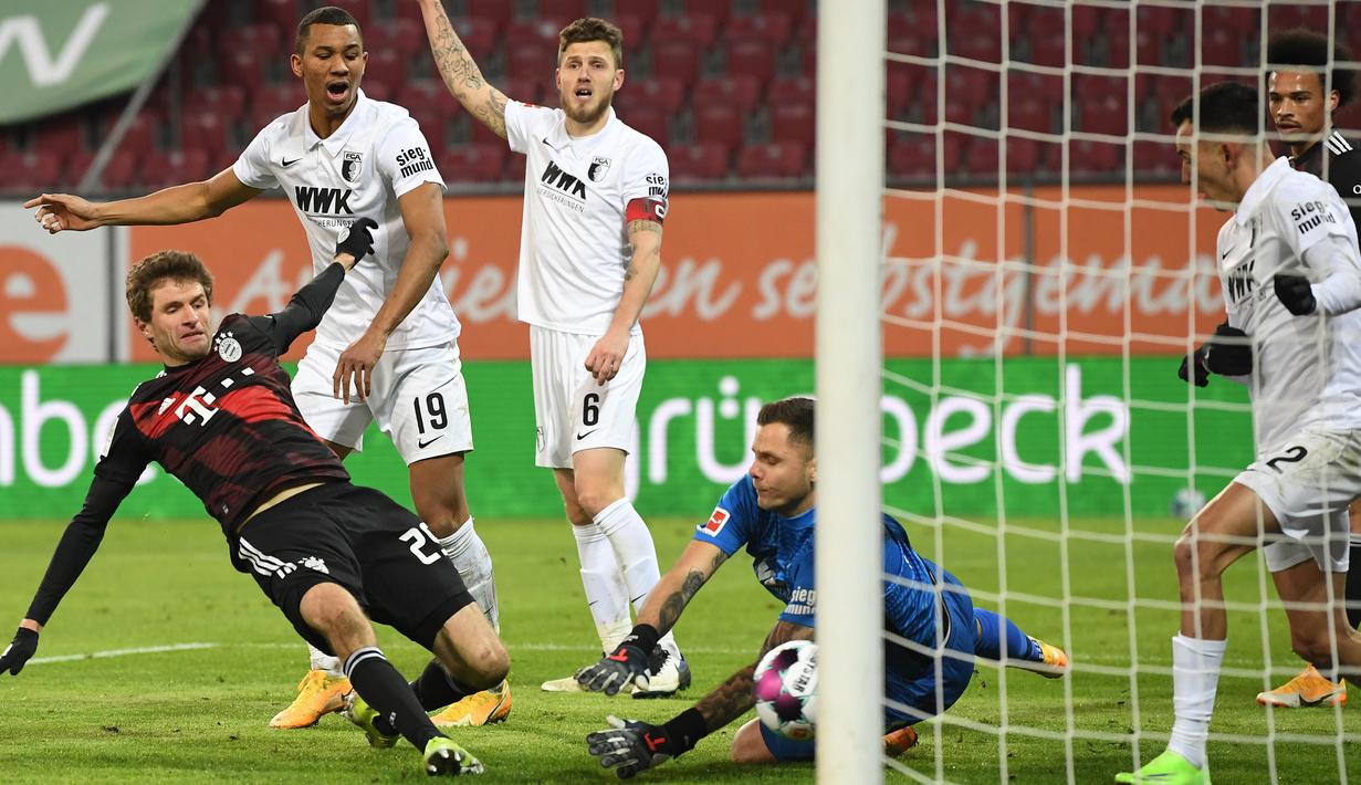 Penyerang Bayern Munchen, Thomas Mueller, berusaha mencetak gol ke gawang Augsburg dalam laga lanjutan Liga Jerman di WWK Arena, Kamis (21/1/2021) dini hari WIB. Bayern Munchen menang 1-0 atas Augsburg. (AFP/Andreas Gebert/pool)