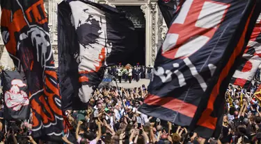 Bendera AC Milan berkibar dari kerumunan pelayat saat peti mati mantan Perdana Menteri Italia Silvio Berlusconi dibawa keluar Katedral Gotik Milan, Italia, setelah pemakaman kenegaraannya, Rabu (14/6/2023). Berlusconi meninggal pada usia 86 tahun karena leukemia kronis. (Alessandro Bremec/LaPresse via AP)