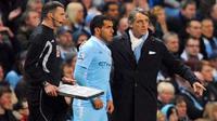 Striker Manchester City Carlos Tevez (tengah) bersiap dimasukkan manajer Roberto Mancini (kanan) pada parai lanjutan Liga Premier kontra Chelsea di Etihad Stadium, Manchester, 21 Mare 2012. AFP PHOTO/ANDREW YATES