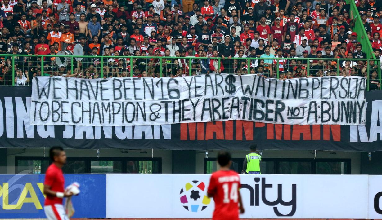 Suporter Persija membentangkan spanduk usai menyaksikan laga timnya melawan Mitra Kukar pada lanjutan Liga 1 Indonesia di Stadion Patriot Candrabhaga, Bekasi, Minggu (14/5). Laga kedua tim berakhir imbang 1-1. (Liputan6.com/Helmi Fithriansyah)