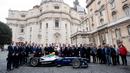 Paus Fransiskus berfoto bersama perwakilan manajer dan pengemudi Kejuaraan Formula FIA ABB di belakang mobil balap listrik Formula E di Vatikan (11/4). (AFP Photo/Media Vatikan)