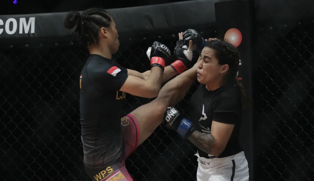 Petarung Indonesia, Priscilla Lumban Gaol, menendang petarung India, Puja Tomar, saat bertarung pada laga ONE Championship di Istora Senayan, Jakarta, Sabtu (19/1). Priscilla kalah dari Puja. (Bola.com/M. Iqbal Ichsan)