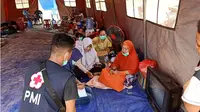 Petugas kesehatan tengah memeriksa kesehatan para pengungsi korban kebakaran Tolitoli di tenda darurat, Senin (3/2/2020). (Liputan6.com/Heri Susanto)