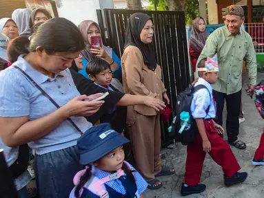 Orang tua mengantarkan anaknya hingga gerbang sekolah  di SDN Meruyung, Depok, jawa Barat, Senin, 13 Juli 2007.