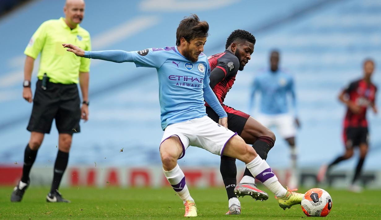 Gelandang Manchester City, David Silva, berebut bola dengan gelandang Bournemouth, Jefferson Lerma, pada laga lanjutan Premier League pekan ke-36 di Etihad Stadium, Kamis (16/7/2020) dini hari WIB. Manchester City menang 2-1 atas Bournemouth. (AFP/Dave Thompson/pool)