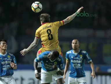 Pemain Persib Bandung, Ezechiel Ndouasel  berebut bola dengan pemain Mitra Kukar, Danny Guthrie pada laga Liga 1 Indonesia di GBLA, (8/4/2018). Persib Bandung menang 2-0. (Bola.com/Nick Hanoatubun)