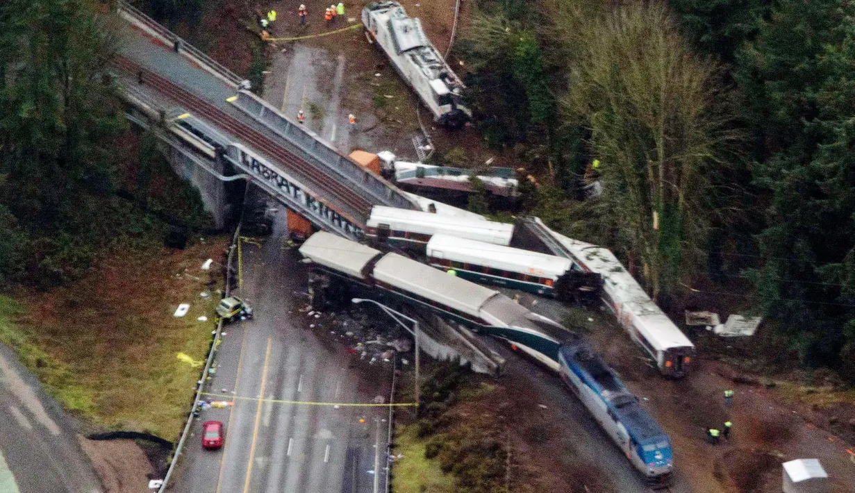 Pemandangan dari udara memperlihatkan Kereta Amtrak usai kecelakaan di Interstate di DuPont, Washington, AS (18/12). Lima kendaraan dan 2 truk semi trailer yang tengah melintas ketabrak kereta tersebut. (AP Photo/John Froschauer)